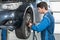 Mechanic Using Pneumatic Wrench To Fix Car Tire