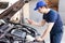 Mechanic using a tester on a car engine