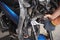 Mechanic using a wrench and socket on the engine of a motorcycle , maintenance,repair motorcycle concept in garage.selective focus