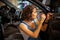 Mechanic woman in a blue overalls repair the door of car