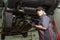 Mechanic woman working on car in his shop