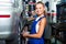 Mechanic woman working on wheel equilibrium control machinery