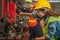 Mechanic workers working with drilling machine in metalwork workshop