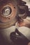 Mechanic working at a car worn and rusty brake disk and caliper