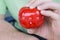 Mechanical red tomato kitchen timer set to 25 minutes , gripped by one hand