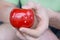 Mechanical red tomato kitchen timer set to 30 minutes , gripped by one hand