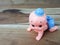 Mechanical wind up crawling baby toy on wood background.