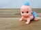 Mechanical wind up crawling baby toy on wood background.