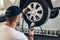 Mechanician changing car wheel in auto repair service