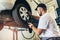 Mechanician changing car wheel in auto repair shop