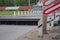 Mechanism of railway crossing barrier device in raised state of obstacle on road. Red-white barrier lowered in front of device