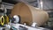 Mechanism reels packaging paper on huge roll at plant