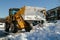 Mechanized tractor for snow removal is parked on a city street after snowfall