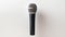 a media journalist's microphone on a light background with ample empty space on the left for text or graphics. The