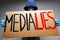 `Media lies` painted on placard in hands of protester man.