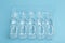 Medical ampoules with a vaccine on a blue background. Medicine for disease or medicine for health concept
