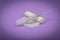 Medical bandage and syringe on a lilac background. A gauze roll on which the syringe lies. Dressing for medical purposes.