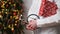 Medical banner concept for Christmas and New Year.Female doctor in white coat holds stethoscope and gift box wrapped in red paper