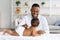 Medical Checkup. Smiling Black Pediatrician Doctor Examining Little Baby With Stethoscope