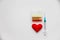 Medical colorful vials for injection syringe and red heart on a white background. Healthy heart. lifestyle. Copy space