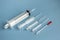 Medical concept of disposable syringes of different volumes on a blue background