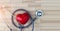 Medical concept, red heart and stethoscope on wooden background.