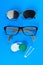 Medical concept. A set of accessories for sight. Top view. Pinhole glasses, lenses with container and glasses for sight