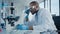 Medical Development Laboratory: Black Male Scientist Looking Under Microscope, Inspecting Petri Di