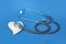 Medical device for listening to a stethoscope, white ceramic heart on a blue background, concept of medicine, cardiology and