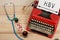 medical diagnosis - doctor workplace with blue stethoscope, pills, red typewriter with text HBV