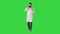 Medical doctor calling by phone walking on a Green Screen, Chroma Key.