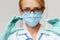 Medical doctor nurse woman wearing protective mask and gloves - holding bottle of vaccine medicine and syringe