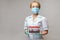 Medical doctor nurse woman wearing protective mask and gloves - holding rack with virus blood tests