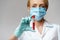 Medical doctor nurse woman wearing protective mask and gloves - holding virus blood test