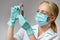 Medical doctor nurse woman wearing protective mask and gloves - holding virus blood test