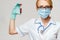 Medical doctor nurse woman wearing protective mask and gloves - holding virus blood test