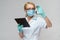 Medical doctor nurse woman wearing protective mask and gloves - holding virus blood test and tablet pc