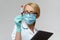 Medical doctor nurse woman wearing protective mask and gloves - holding virus blood test and tablet pc