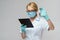 Medical doctor nurse woman wearing protective mask and gloves - holding virus blood test and tablet pc