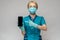 Medical doctor nurse woman wearing protective mask and gloves - showing presenting mobile phone