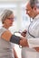 A medical doctor takes a patient s blood pressure.