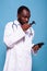 Medical doctor in white lab coat with stethoscope looking worried at otoscope