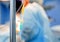 Medical drop counter on the blurry background of the group of doctors in the operating room. Closeup. Vertical.