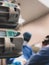 Medical drug infusion pumps in the foreground with 2 surgeons operating in the background selective focus - scene from operatin