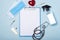 Medical equipment mockup clipboard, stethoscope with red heart and drug, surgical mask on blue copy space background