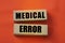 Medical error text on wooden blocks on red. Healthcare concept