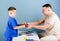 Medical examination. Medical service. Man doctor sit table medical tools examining little boy patient. Health care