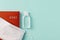 Medical face mask on a 2021 year red leather diary and hand sanitizer on a pale turquoise background. Planning your life and