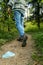 Medical face mask littering in nature.Unrecognizable man walks away after dropping a mask on the ground on a footpath in the