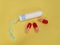 Medical female cotton tampon and three capsules with medicine on a yellow background